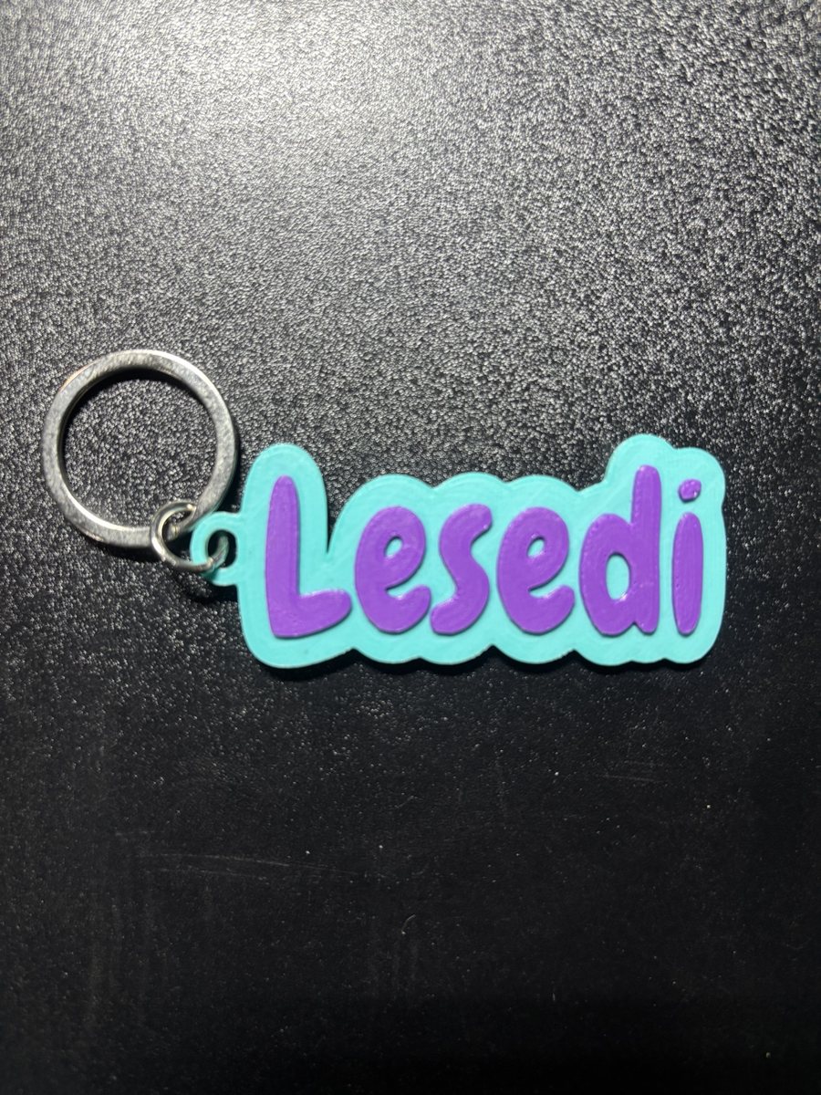 Turquoise 3D-printed name tag with the name Lesedi in purple